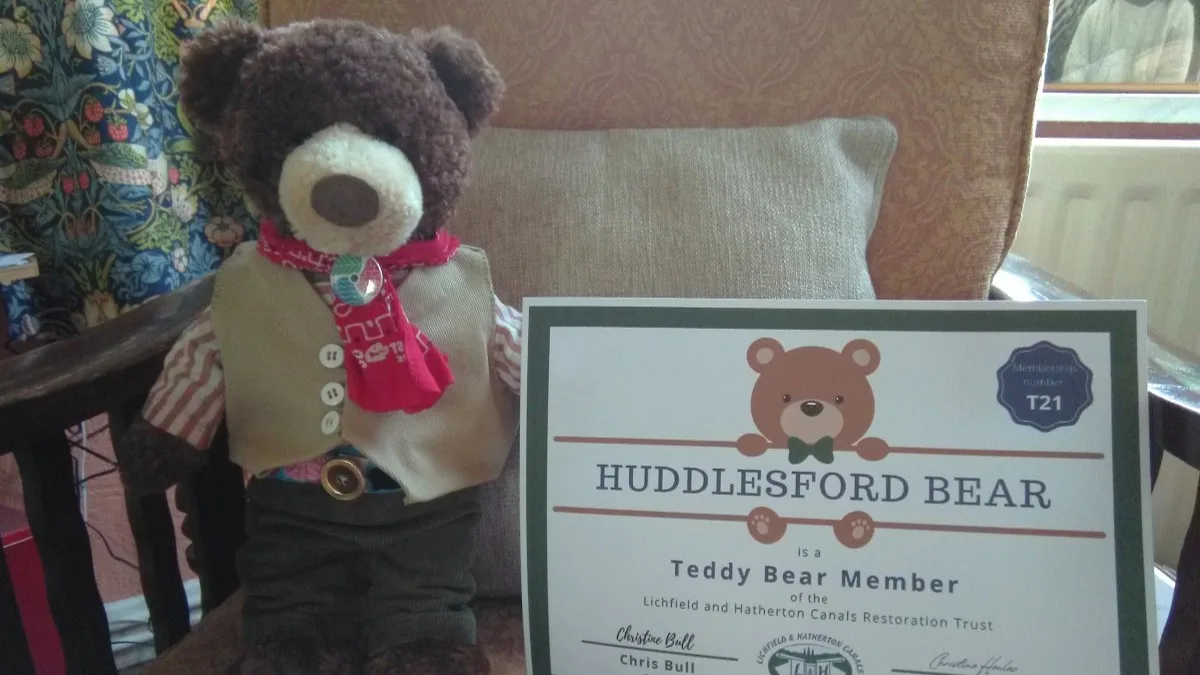 A photo of a bear with his membership certificate.