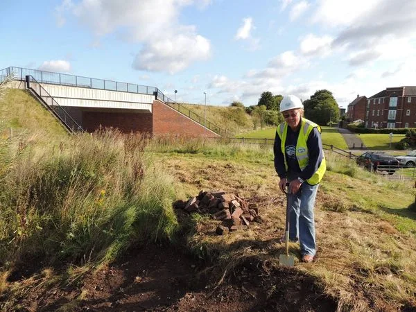 A photo of Chris Bull breaking ground with a spade at Fosseway